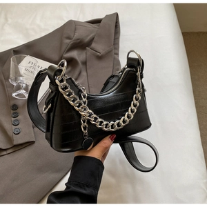 Detail of black crescent hobo bag with crocodile embossing and chunky silver chain