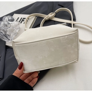 Détails de la structure du fond du sac seau crème avec sa fine bandoulière réglable