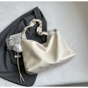 Detail of off-white tote bag with pleated texture and cute white cloud charm