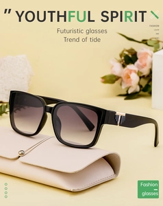 Detail view of square black sunglasses with gold T-shaped hinges and a leather case