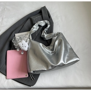 Detail of silver metallic tote bag with pleated shoulder strap and white cloud charm