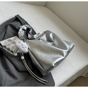 Close-up of silver tote bag with crinkled metallic texture and cute cloud charm accessory