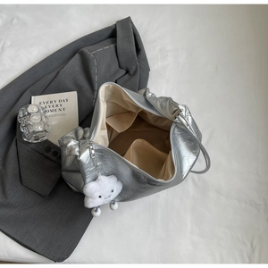 Close-up of silver quilted tote bag interior with multiple pockets and cloud charm