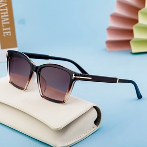 Cat-eye sunglasses with gradient frames and golden T-hinges on a modern blue background