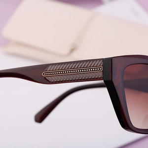 Macro shot of stylish cat-eye sunglasses featuring golden temple metal inlay and textures