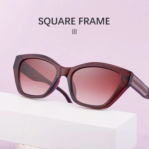 Detail of square frame sunglasses in deep red with gradient lenses and arrow metal accent
