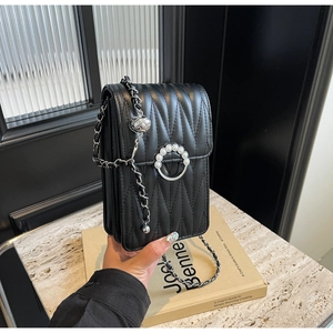 Dettaglio borsa trapuntata nera con chiusura di perle e finitura con trama a onde