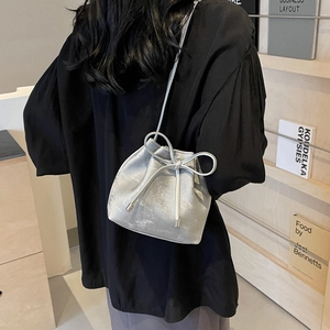 Sac seau argenté métallisé avec nœud et cordon de serrage sur modèle chic