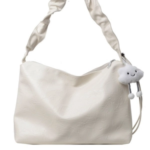 Minimalist beige tote bag with a pleated shoulder strap and a cute cloud charm accessory