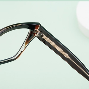 Detail of golden metal pattern inlay on the hinge and temple of cat eye glasses frame