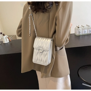 Dettaglio della borsa trapuntata argento con fibbia di perle su una modella