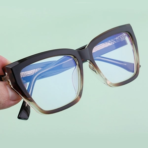 Close-up of black tea gradient square glasses with intricate metal diamond pattern on temples