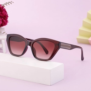 Stylish cat eye sunglasses with gradient lenses and burgundy frames on a modern display