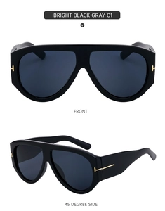 Detail of oversized black sunglasses with iconic gold T metal accent on front and side