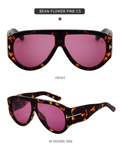 Detail view of large tortoiseshell sunglasses with pink gradient lenses and metal T-accents