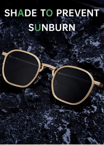 Détail de lunettes de soleil carrées en métal doré sur roche sombre avec double pont