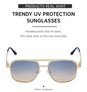 Close-up of double bridge pilot sunglasses with gold metal frame and gradient UV lenses