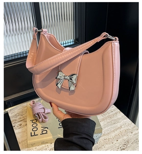 Rosa Schultertasche aus Kunstleder mit silberner Metallschleife und Kettenriemen