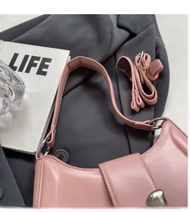 Detail der rosa halbmondförmigen Schultertasche mit glattem Kunstleder und Silberringen
