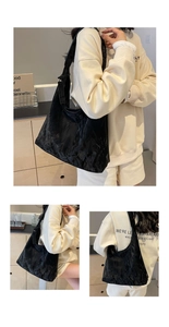 Detail of black cloud-textured tote bag with pleated leather effect and wide shoulder strap