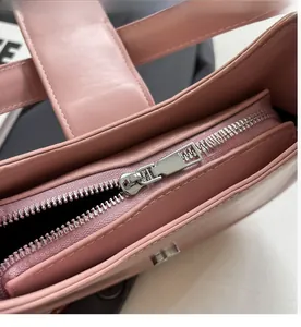 Detailaufnahme des silbernen Metallreißverschlusses und des rosa Leders der Handtasche
