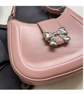 Detail einer rosa französischen Umhängetasche mit einer polierten silbernen Metallschleife