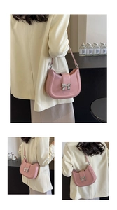 Detailansicht der rosa Ledertasche mit silberner Schleife an der Schulter des Models