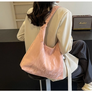 Detail of pink hobo tote bag with crinkled leather texture and wide shoulder strap