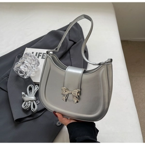 Detailansicht einer silbernen Hobo-Tasche mit Metallscheife und abnehmbarem Schultergurt