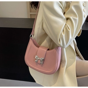 Details der rosa Mondsichel-Tasche mit Silberschleife und Schultergurt am Model