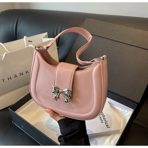 Detailansicht der rosa Ledertasche mit silberner Metallschleife und modischem Kettenriemen