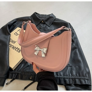 Detailansicht der rosa Achseltasche aus Leder mit einer silbernen Metallschleife