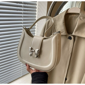 Nahaufnahme der cremefarbenen Hobo-Tasche mit silberner Metallschleife und glattem Leder