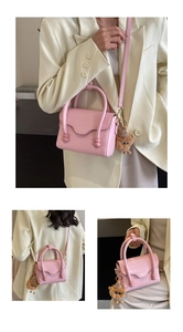 Detail of pink croc-embossed mini bag with metal clasp and cute plush bear charm