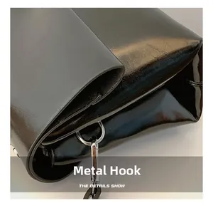 Macro shot of durable silver metal hook and glossy oil leather texture on a shoulder bag