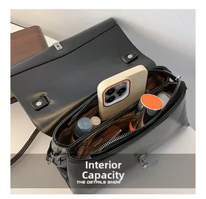 Internal view of black leather crossbody bag showing dual compartments and daily essentials