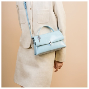 Close-up of light blue leather bag featuring silver metal lock and key pendant detail