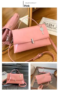 Pink faux leather shoulder bag with a silver buckle and elegant key charm detail