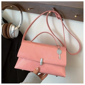 Pink matte leather bag on wooden hook with silver clasp and key pendant detail