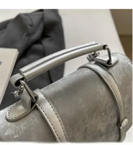 Close-up of the silver-grey leather bag handle with metallic buckle and vintage texture