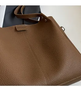 Detail of brown lychee grain leather texture with reinforced rivets and stitching