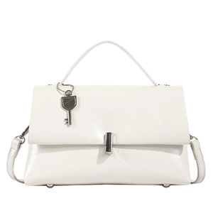 Macro shot of white synthetic leather bag with silver metal lock and key charm detail
