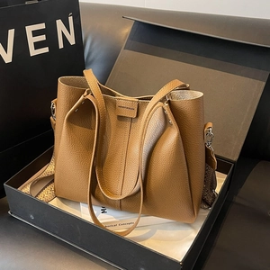 Brown lychee leather tote bag with a wide ethnic woven strap in a premium gift box