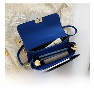 Interior view of blue crossbody bag with gold lock showing spacious compartments for daily items