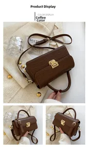 Detail of coffee brown crocodile-embossed leather handbag with elegant gold hardware