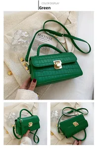 Detail of green crocodile textured handbag with golden push-lock and elegant handle