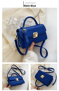 Detail of Klein Blue handbag featuring crocodile texture and golden metal buckle closure