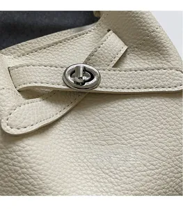 Details aus cremefarbenem Leder mit Lychee-Narbung und silbernem Drehverschluss