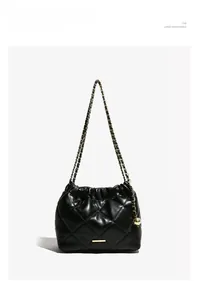 Detail of black quilted shoulder bag with gold chain strap and spherical adjuster