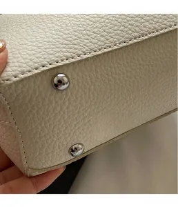 Detailaufnahme der elfenbeinfarbenen Ledertasche mit schützenden silbernen Metallfüßen